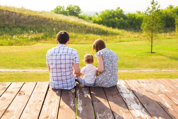 Premium Photo | Rear view of mother, father and son sitting together ...