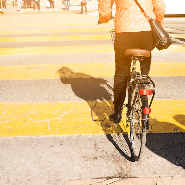 路上で自転車に乗る女性の後姿 無料の写真