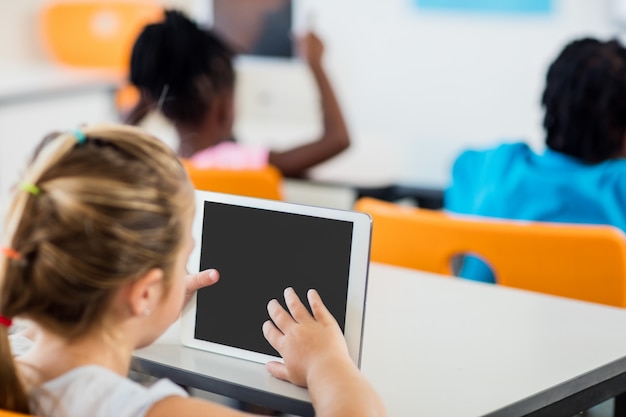 Rear view of pupil using tablet pc in classroom Premium Photo