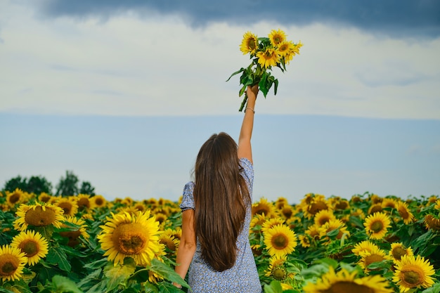 Premium Photo | Rear view of a woman with sunflowers bouquet. young ...