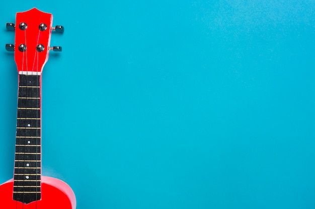 Premium Photo | Red acoustic guitar on blue backdrop