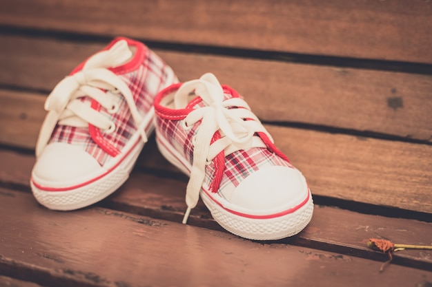 Premium Photo | Red baby shoes on wooden chair