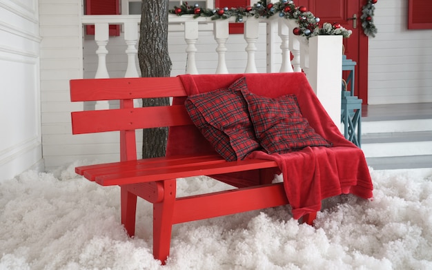 赤い毛布と屋外の白い人工雪と赤いベンチのクッション プレミアム写真