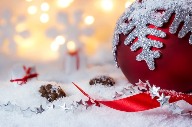 Premium Photo | Red christmas ball with snowflake on the snow and bokeh ...