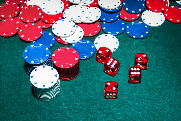 Red dices and casino chips on green poker table | Free Photo