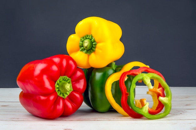 Premium Photo | Red green yellow peppers whole and sliced on black ...