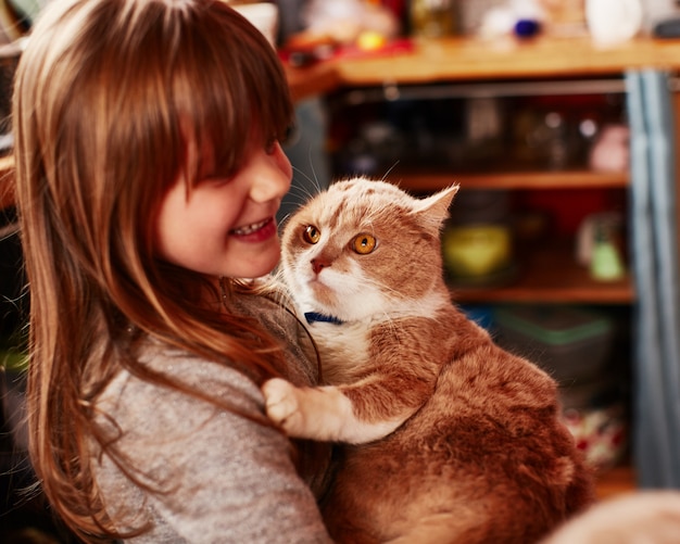 The red-haired girl holds the red-haired cat | Free Photo