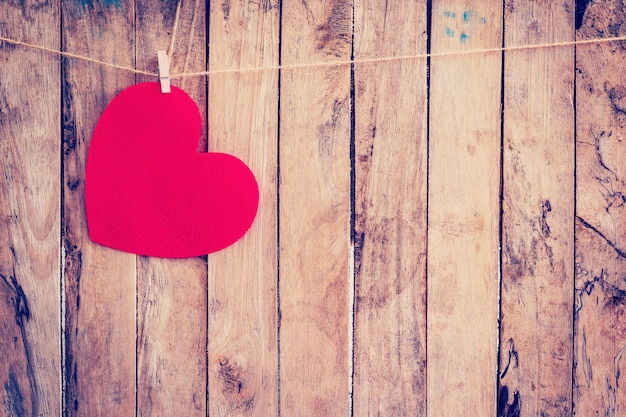 Premium Photo | Red heart hanging on clothesline and rope with wooden ...