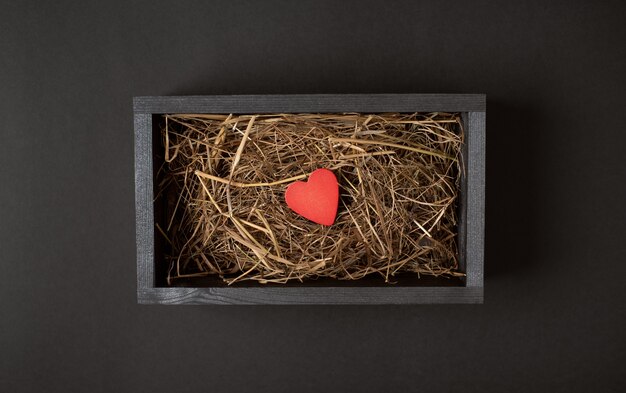 Premium Photo A Red Heart Inside Black Wooden Box With Hay Dry Grass On The Dark Black Background Valentine S Day Concept Flat Lay Top View