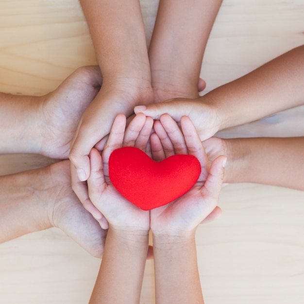 Premium Photo | Red heart in parent and children holding hands together ...