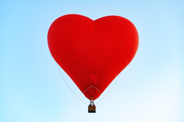 Premium Photo | Red heart-shaped air balloon flying in the clear sky