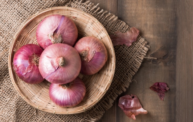 Premium Photo | Red onions in bamboo basket and on wood background ...