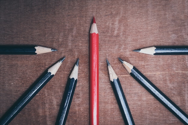 Red Pencil Standing Out From Crowd Of Plenty Identical Black Fellows Premium Photo