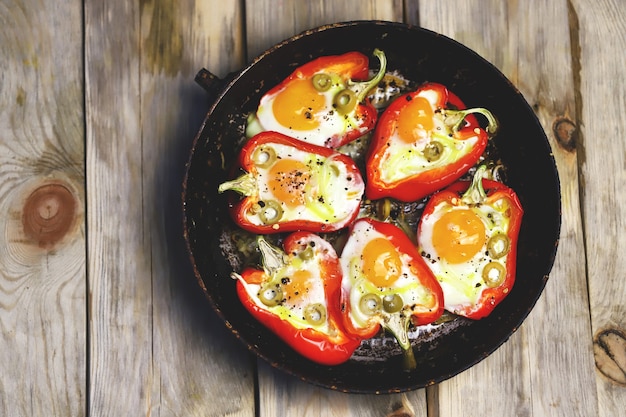 Red peppers with eggs baked in a frying pan Premium Photo