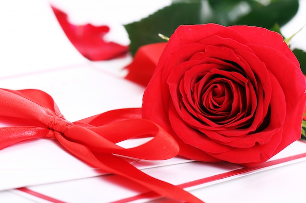 Red rose and holiday envelope Free Photo