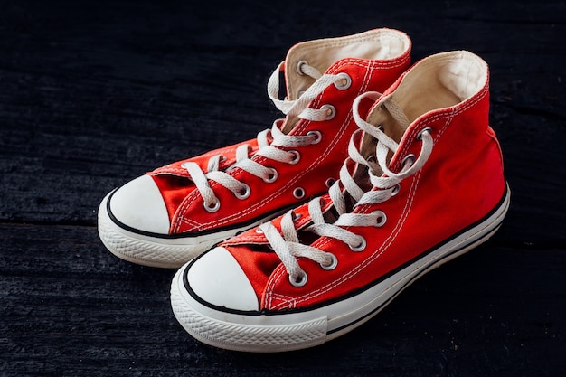 Premium Photo | Red sneakers on black wooden background