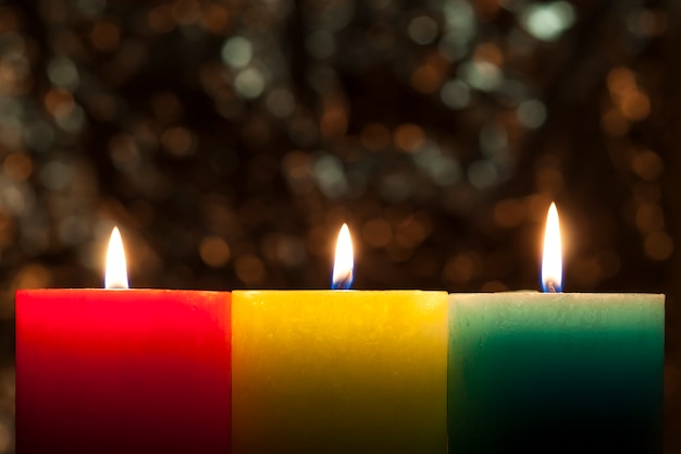Red, yellow and green colourful candles with blurred bokeh background. christmas and new year copy space. Premium Photo
