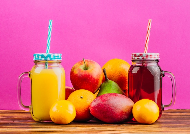 Download Free Photo Red And Yellow Juice Mason Jars With Drinking Straws And Fresh Fruits Against Pink Background PSD Mockup Templates