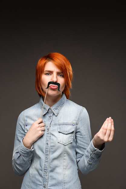 Free Photo Redhead Woman Holding Fake Moustache Grimacing