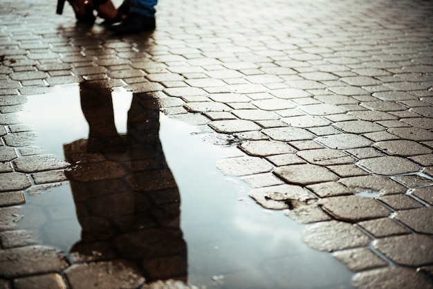 Premium Photo | Reflected in a puddle couple outdoors road