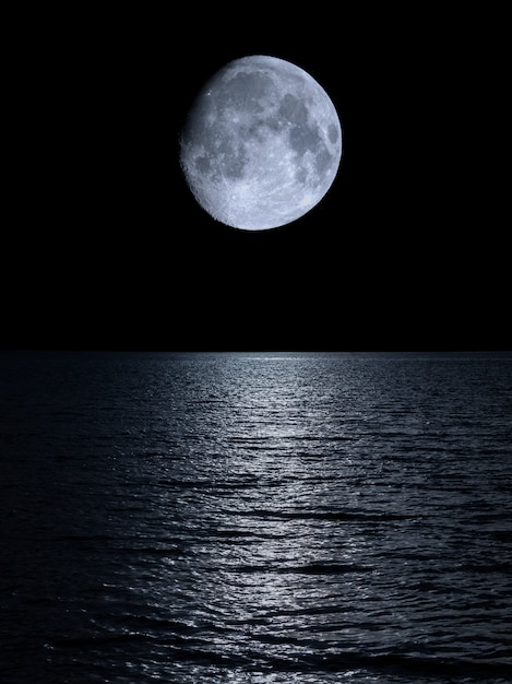 Premium Photo | Reflection of the moon over the calm sea