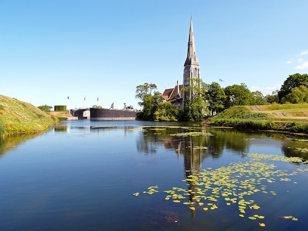 Premium Photo | Reflections of st. alban's church on the pond of the ...