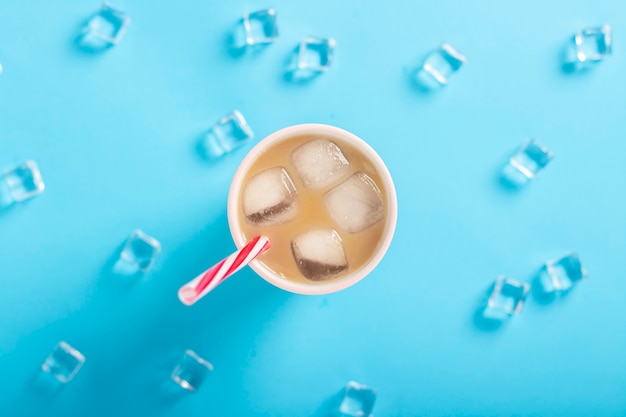 牛乳と氷のガラス 青い背景にアイスキューブでコーヒーを更新します コンセプト夏 氷 さわやかなカクテル 喉の渇き フラット横たわっていた トップビュー プレミアム写真
