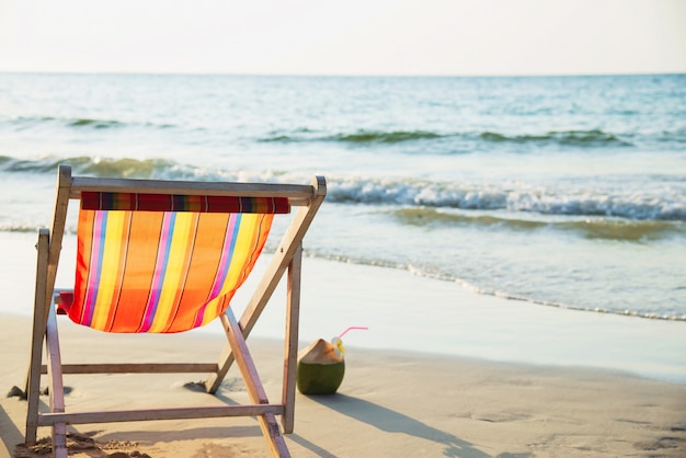 Relax beach chair with fresh coconut on clean sand beach with blue sea