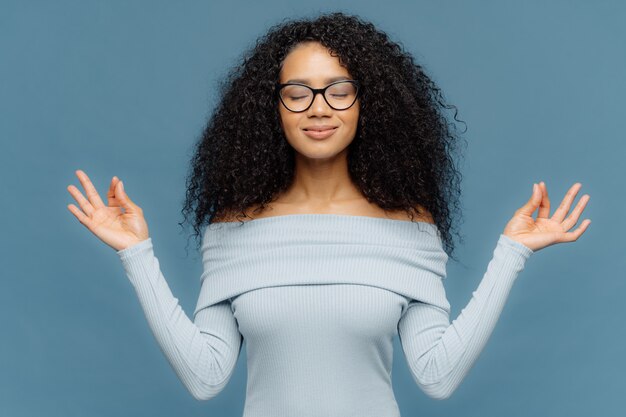 Relaxed Beautiful Woman With Afro Hairstyle Feels Relieved Shows