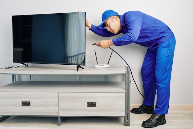  Repairman installing tv set Premium Photo