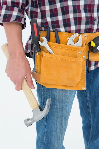 Premium Photo | Repairman wearing tool belt while holding hammer