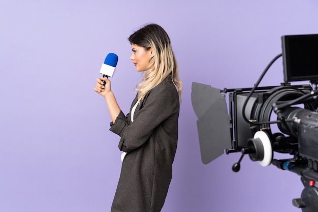 Premium Photo | Reporter young woman holding a microphone and reporting ...