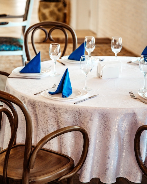 白いレースのテーブルクロスと青いナプキンのレストランのテーブル 無料の写真