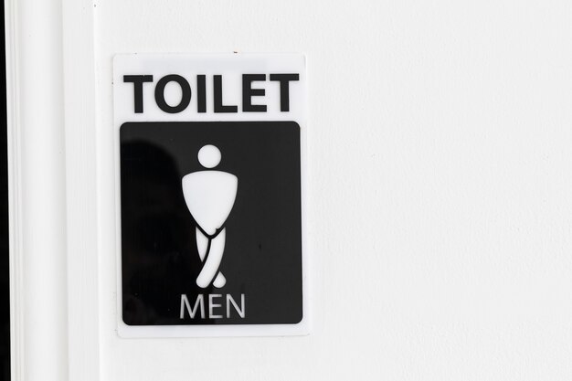 Restroom sign with copy space on white wall Premium Photo