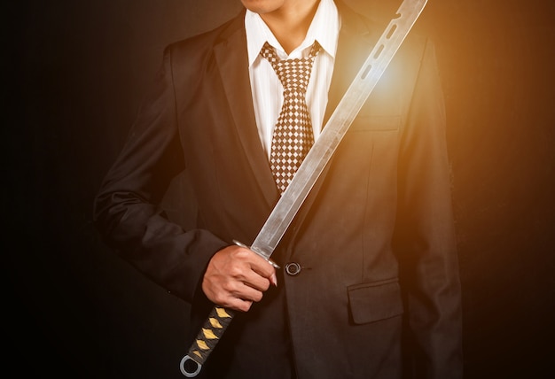 Premium Photo The Right Hand Of A Businessman Holding A Sword On A