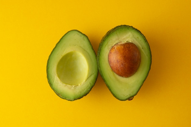 Premium Photo | Ripe fresh avocado sliced isolated on yellow background.