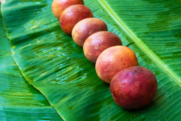 濡れたバナナの葉の上に熟したパッションフルーツ ビタミン 果物 健康食品 プレミアム写真