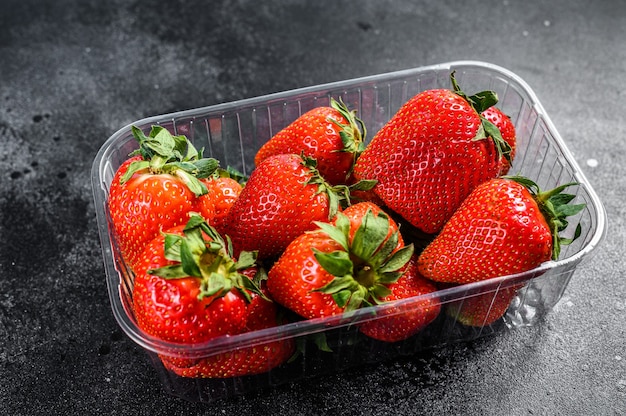 Download Premium Photo Ripe Red Strawberries In Plastic Packaging Black Background Top View