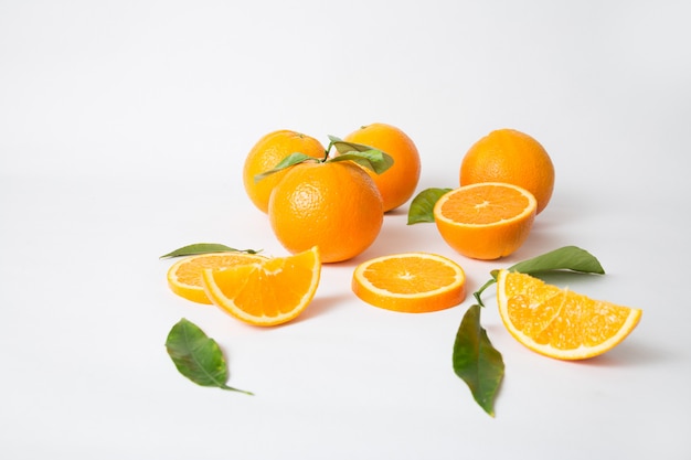 Free Photo | Ripe whole oranges with green leaves and sliced parts