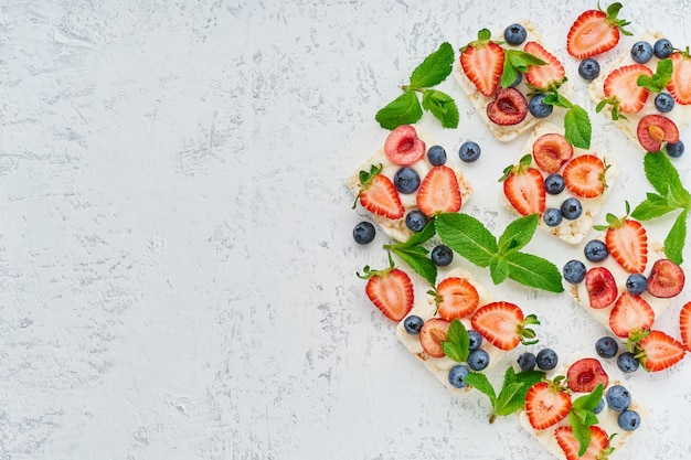 Rise crispbread with berries and fruits colorful concept on pastel background copy space top view Premium Photo