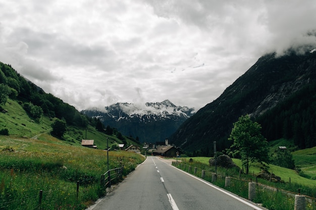 Road in swiss alps mountains in summer cloudy weather Photo | Free Download
