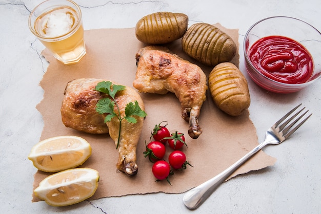 Coscia Di Pollo Arrosto Patate Bollite Salsa Pomodoro Ciliegino Limone Forchetta E Birra Per Cena Su Sfondo Stagionato Foto Gratis