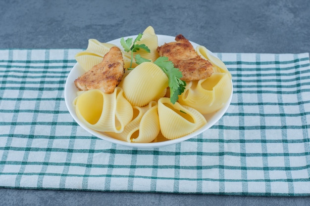 Free Photo | Roasted chicken nuggets and boiled pasta in white bowl.