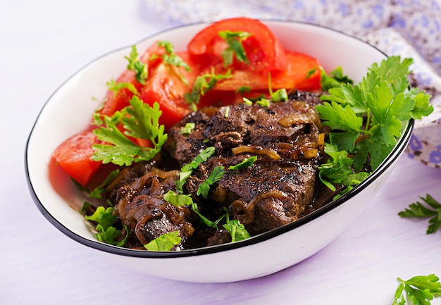 Roasted or grilled beef liver with onion and tomatoes salad Free Photo