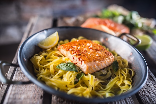 Premium Photo | Roasted salmon fillet with pasta tagliatelle lemon and ...