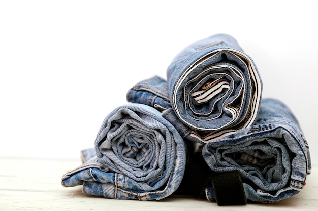 Premium Photo | Roll blue denim jeans arranged in stack