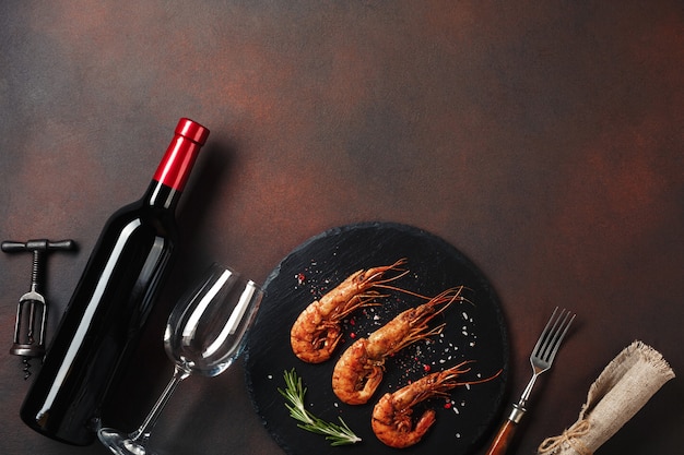 Romantic dinner with heart-shaped shrimps and wine on a brown background. top view with copy space Premium Photo
