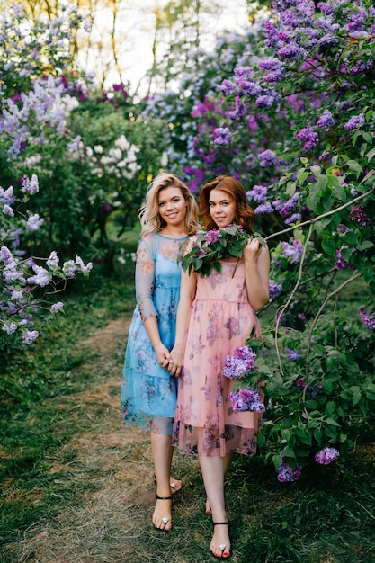 Romantic portrait of twin sisters in tender dresses posing