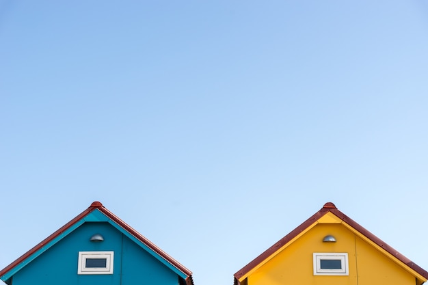 Roofs of small blue and yellow houses with copyspace in the sky Free Photo