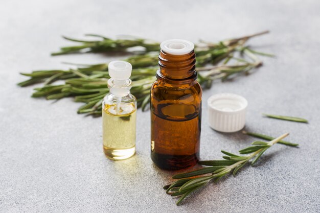 Premium Photo | Rosemary essential oil in a glass bottle with fresh ...